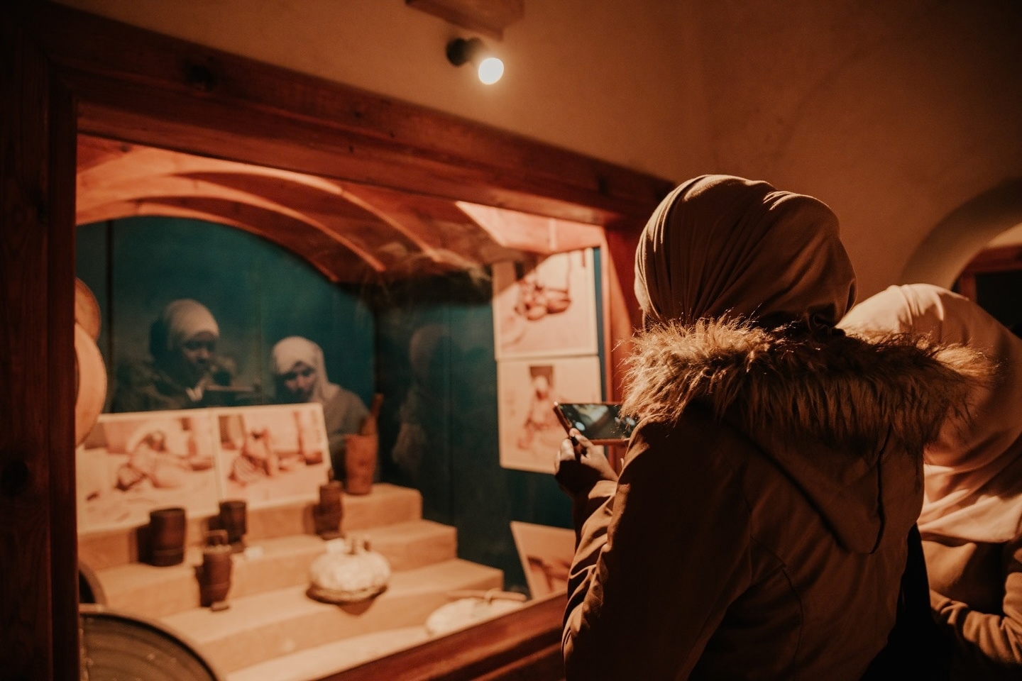 A participant photographing traditional crafts on display during a field visit
