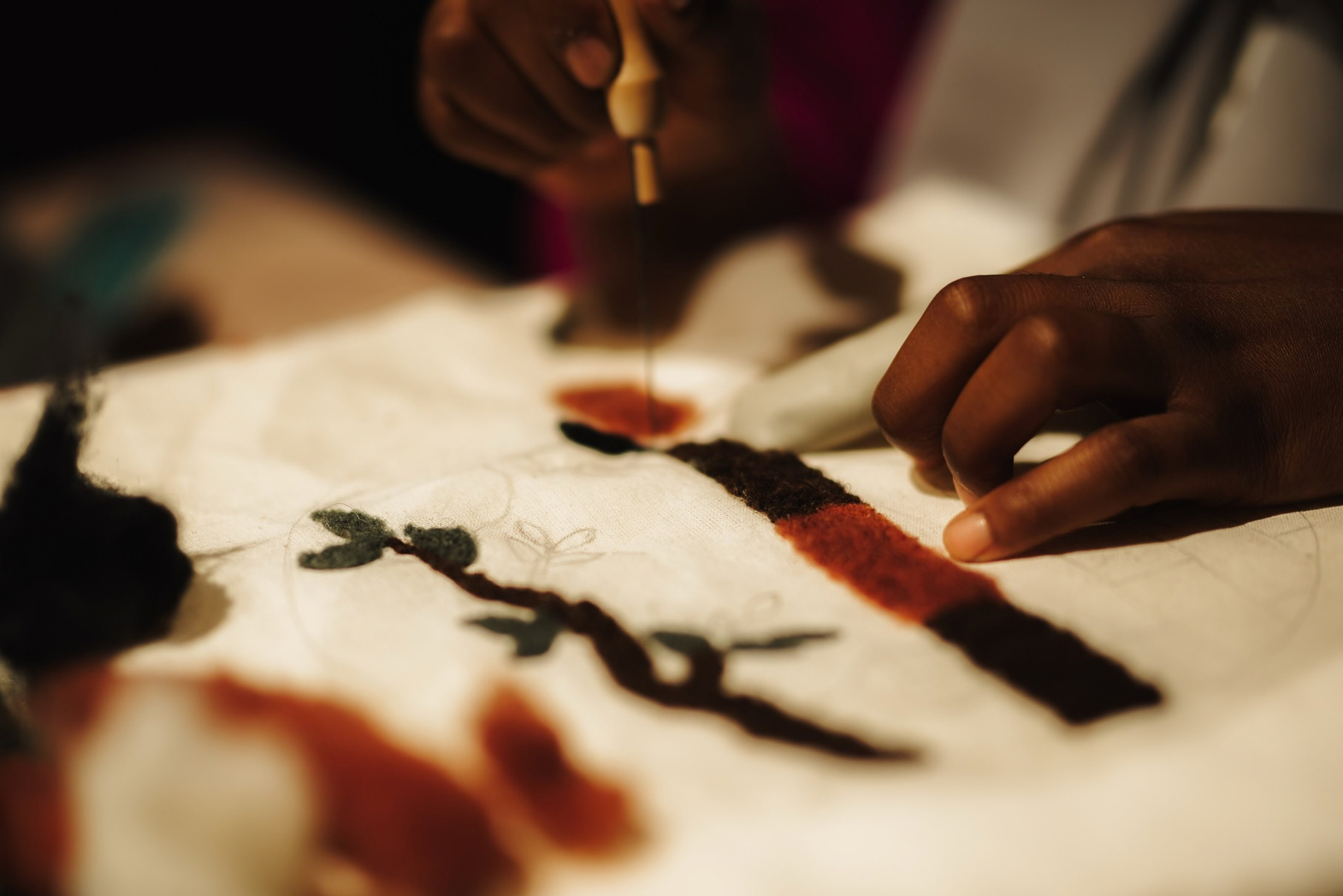 Needle felting a design in wool on cloth