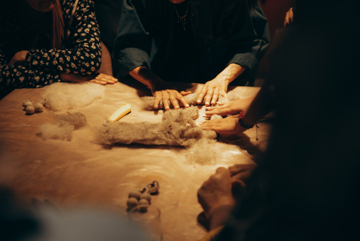 Hands pressing wool together in a felting workshop
